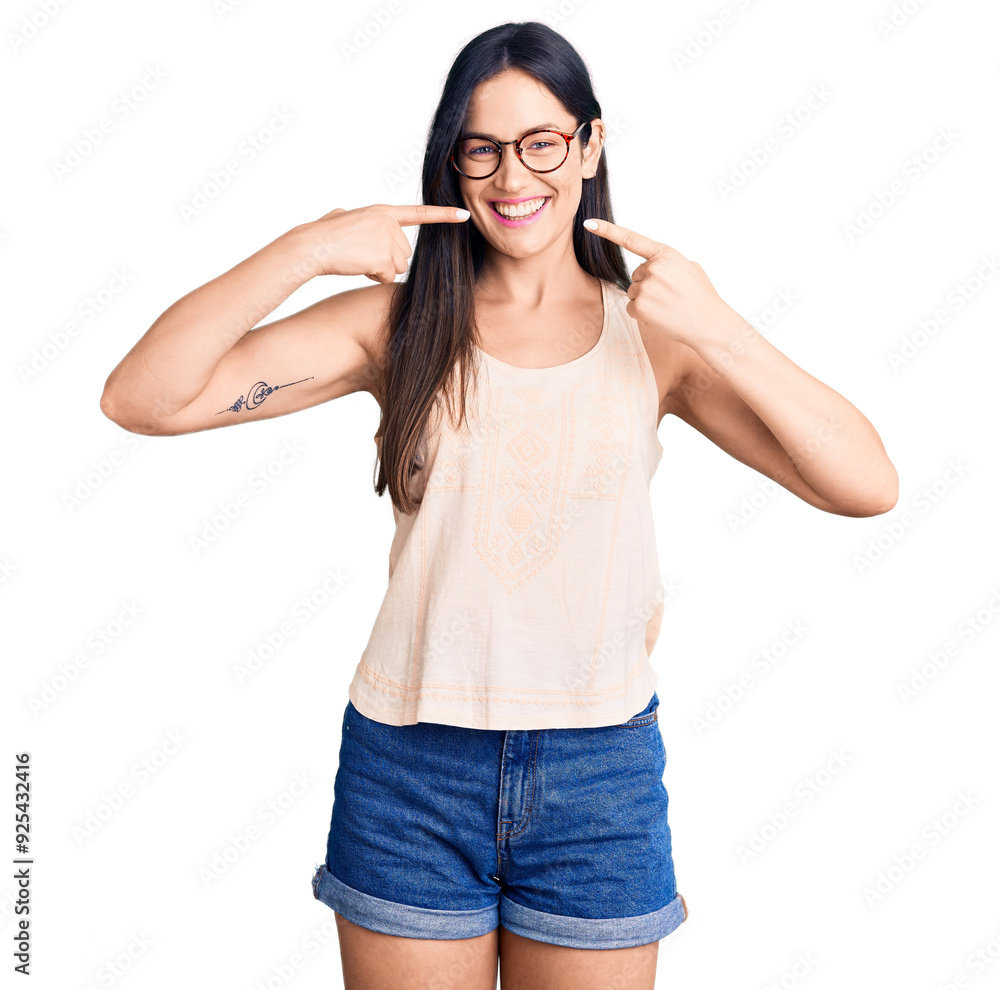 Young beautiful caucasian woman wearing casual clothes and glasses smiling cheerful showing and pointing with fingers teeth and mouth. dental health concept. Young beautiful caucasian woman wearing casual clothes and glasses smiling cheerful showing and pointing with fingers teeth and mouth. dental health concept.