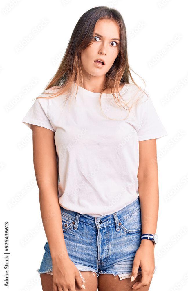 Beautiful caucasian woman wearing casual white tshirt in shock face, looking skeptical and sarcastic, surprised with open mouth Beautiful caucasian woman wearing casual white tshirt in shock face, looking skeptical and sarcastic, surprised with open mouth