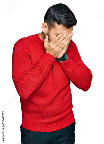 Young hispanic man wearing casual clothes with sad expression covering face with hands while crying. depression concept.