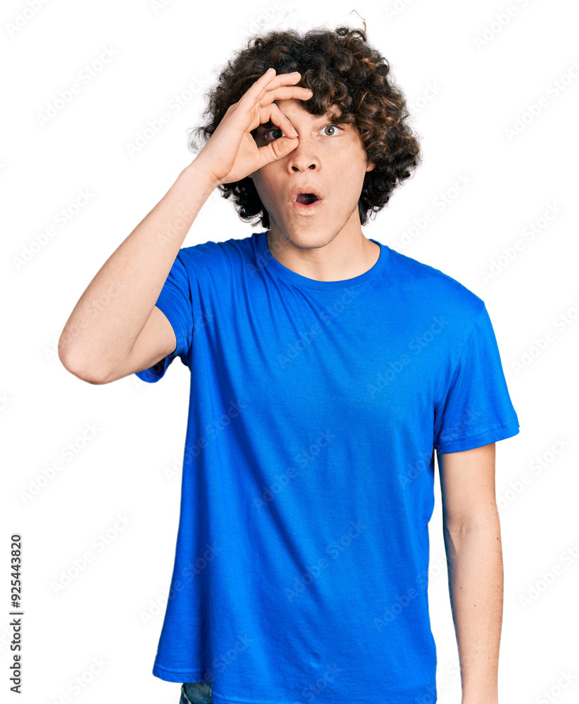 Caucasian teenager wearing casual clothes doing ok gesture shocked with surprised face, eye looking through fingers. unbelieving expression.