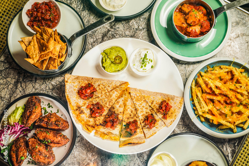 Assorted fastfood verity Tortilla Chips with Tomato Salsa Sauce, Poutine Cheese Fries with Gravy Sauce, Crispy Chicken Wings, Meatballs with Tomato Sauce photo