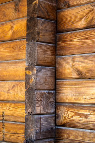 Wood corner of a old building with dovetail joints.  Tree stumps. photo