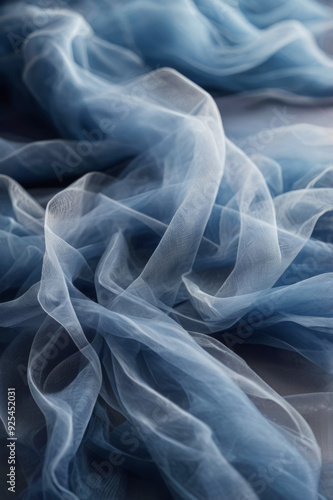 Light airy blue fabric background made of organza or tulle with beautiful folds, fabric texture with waves