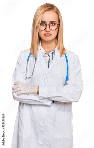 Beautiful caucasian woman wearing doctor uniform and stethoscope skeptic and nervous, disapproving expression on face with crossed arms. negative person.