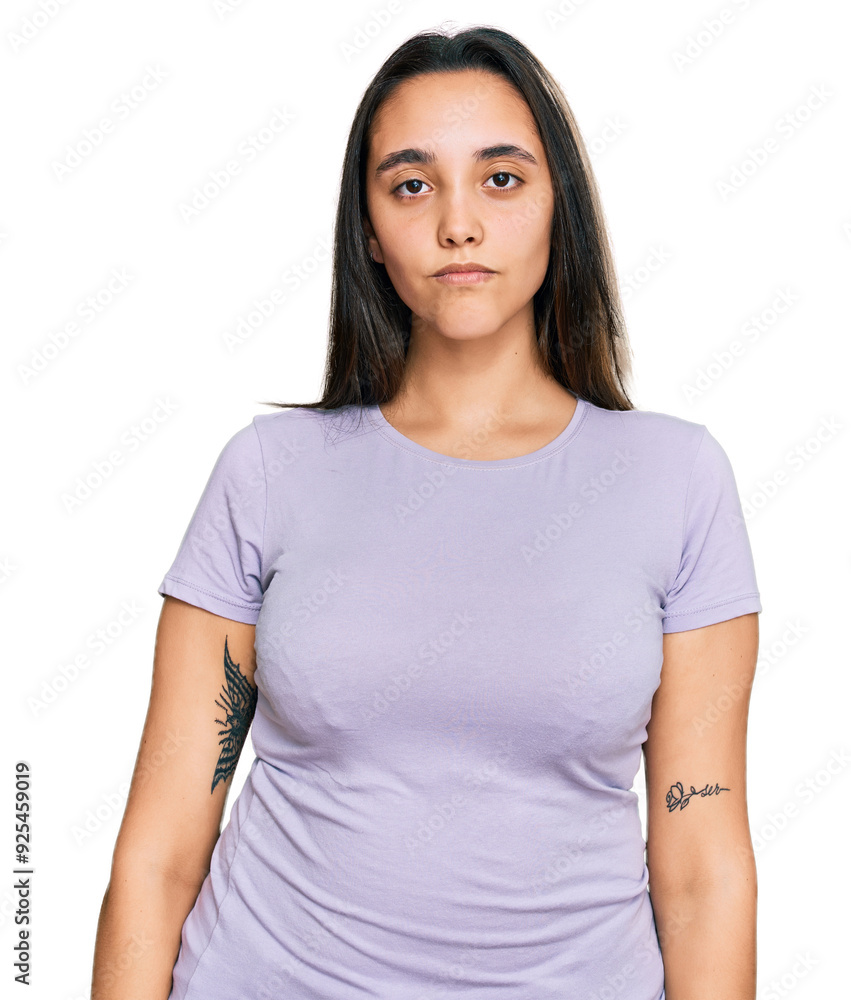 Young hispanic woman wearing casual clothes with serious expression on face. simple and natural looking at the camera. Young hispanic woman wearing casual clothes with serious expression on face. simple and natural looking at the camera.