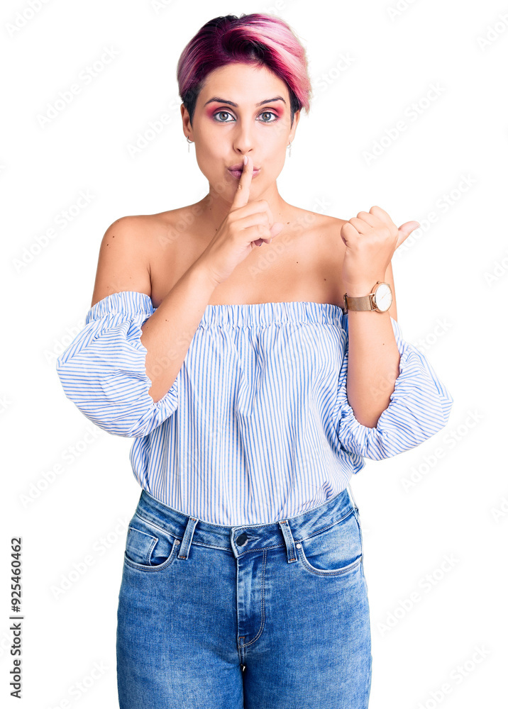 Young beautiful woman with pink hair wearing casual clothes asking to be quiet with finger on lips pointing with hand to the side. silence and secret concept. Young beautiful woman with pink hair wearing casual clothes asking to be quiet with finger on lips pointing with hand to the side. silence and secret concept.