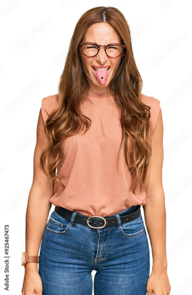 Young hispanic woman wearing casual clothes and glasses sticking tongue out happy with funny expression. emotion concept. Young hispanic woman wearing casual clothes and glasses sticking tongue out happy with funny expression. emotion concept.