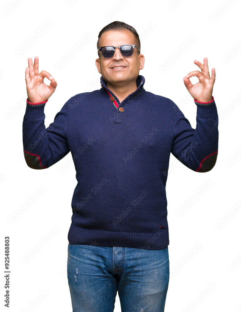 Middle age arab man wearing sunglasses over isolated background relax and smiling with eyes closed doing meditation gesture with fingers. Yoga concept. Middle age arab man wearing sunglasses over isolated background relax and smiling with eyes closed doing meditation gesture with fingers. Yoga concept.