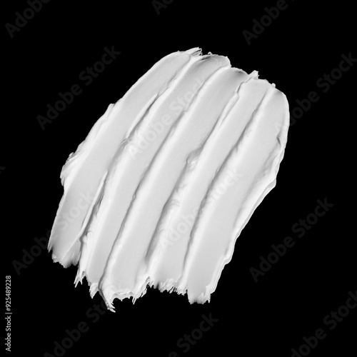 White moisturising cream swatch. Face lotion or mask strokes. Butter cream. Skin care sample. Cosmetic smudge on black background closeup. Beauty product. Top view.