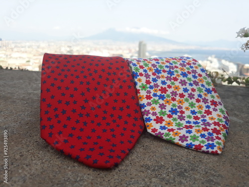 two folded patterned silk ties, isolated on city background photo