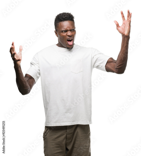 Young african american man wearing white t-shirt crazy and mad shouting and yelling with aggressive expression and arms raised. Frustration concept.