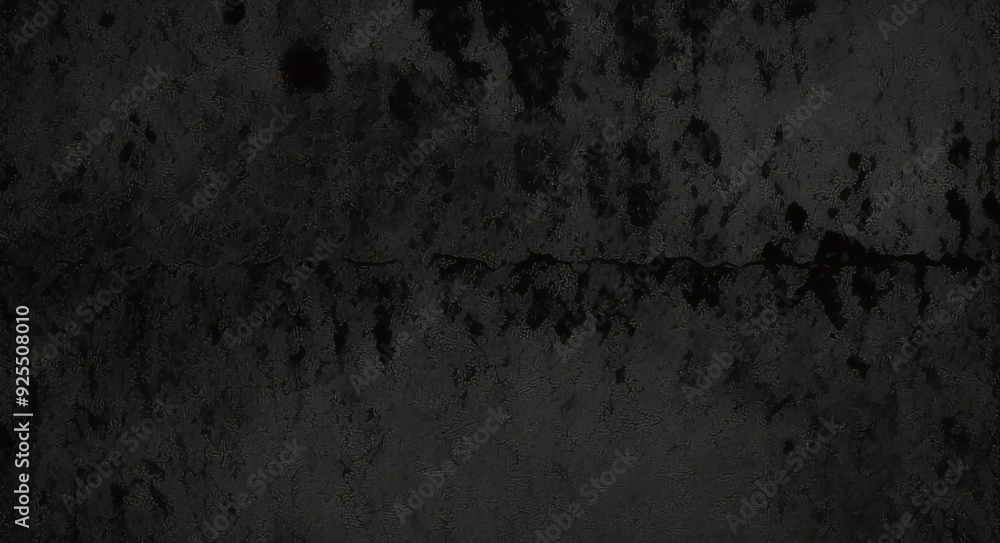 Obraz premium Black background made of real, shiny black paper covered with foil, illuminated by a soft light from above. 