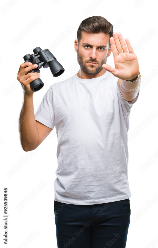 Young handsome man looking through binoculars over isolated background with open hand doing stop sign with serious and confident expression, defense gesture Young handsome man looking through binoculars over isolated background with open hand doing stop sign with serious and confident expression, defense gesture