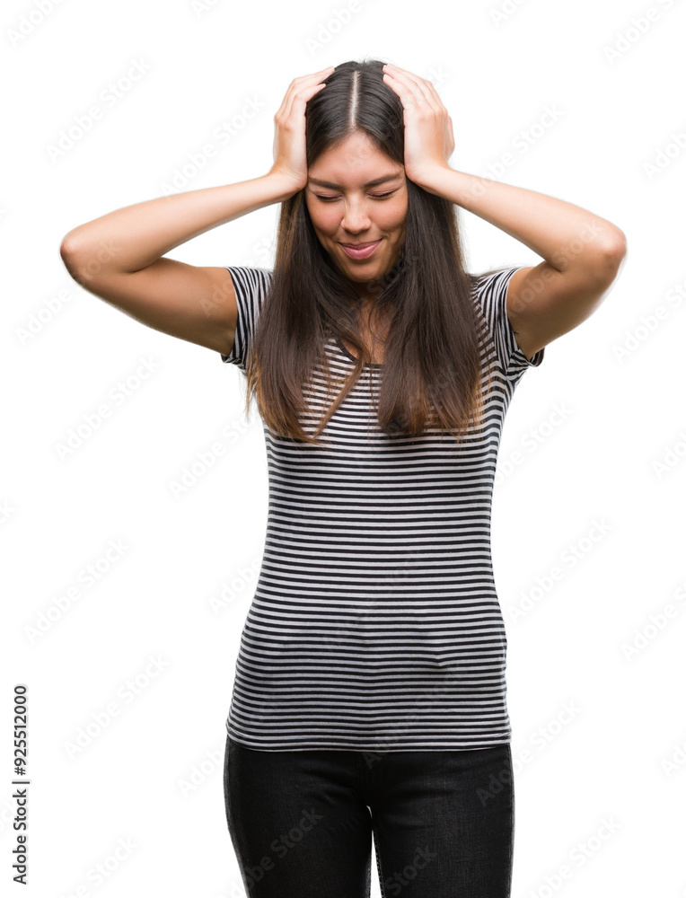 Young beautiful hispanic woman suffering from headache desperate and stressed because pain and migraine. Hands on head. Young beautiful hispanic woman suffering from headache desperate and stressed because pain and migraine. Hands on head.