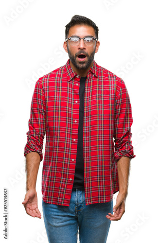 Adult hispanic man wearing glasses over isolated background afraid and shocked with surprise expression, fear and excited face.