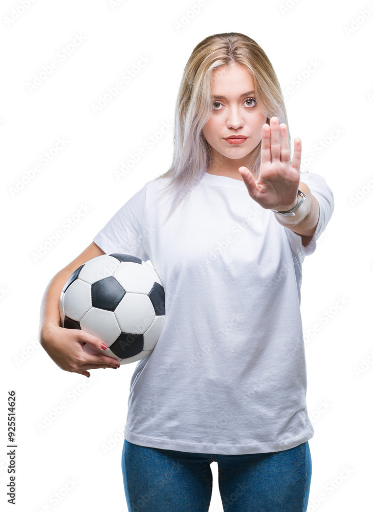 Young blonde woman holding soccer football ball over isolated background with open hand doing stop sign with serious and confident expression, defense gesture Young blonde woman holding soccer football ball over isolated background with open hand doing stop sign with serious and confident expression, defense gesture