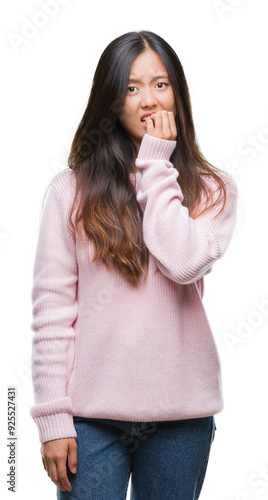 Young asian woman over isolated background looking stressed and nervous with hands on mouth biting nails. Anxiety problem.