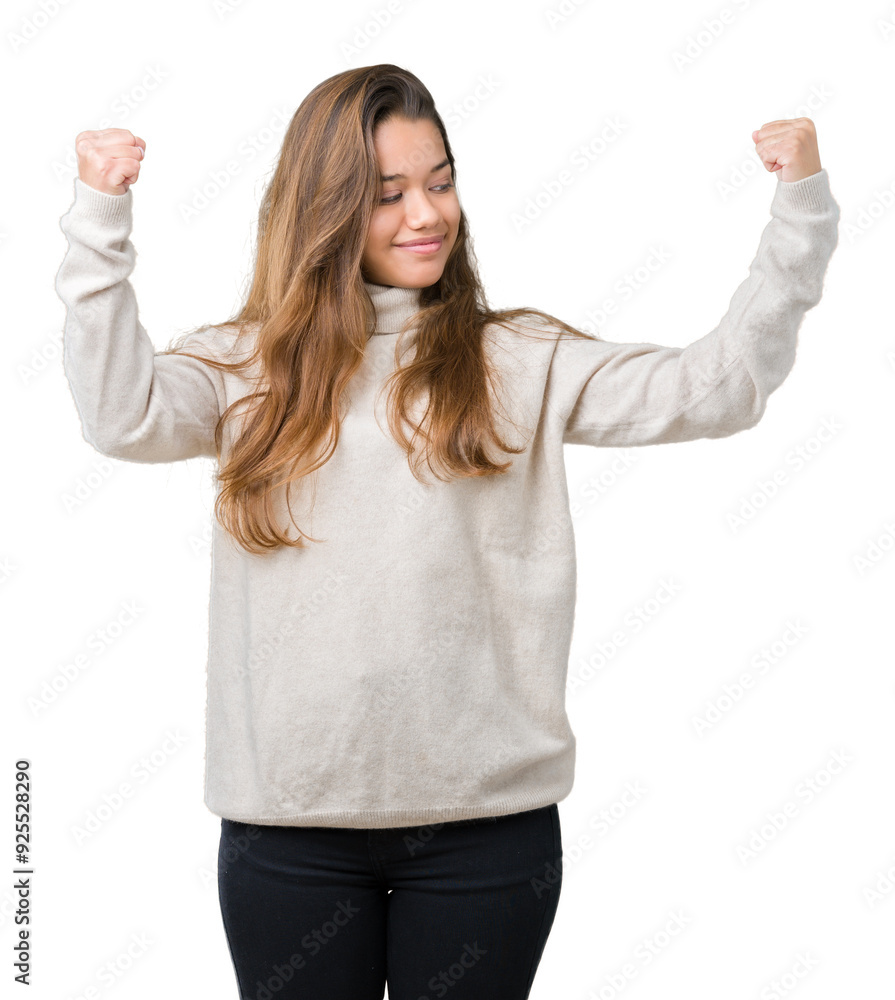 Young beautiful brunette woman wearing turtleneck sweater over isolated background showing arms muscles smiling proud. Fitness concept. Young beautiful brunette woman wearing turtleneck sweater over isolated background showing arms muscles smiling proud. Fitness concept.
