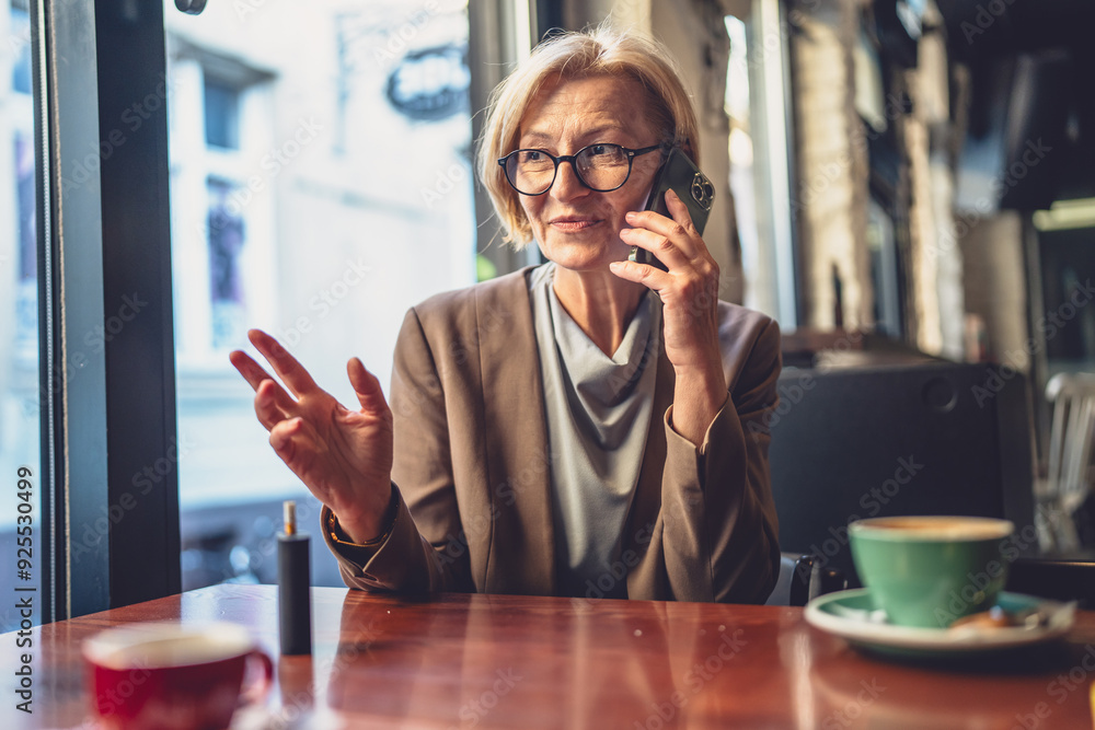One mature woman caucasian blonde female use mobile phone smartphone One mature woman caucasian blonde female use mobile phone smartphone