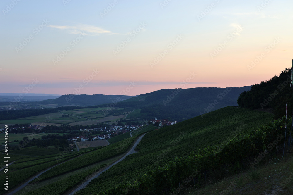 Obraz premium In der Abenddämmerung wurde der Ort Hohenhaslach bei Sachsenheim inmitten einer wunderschönen Weinlandschaft fotografiert.