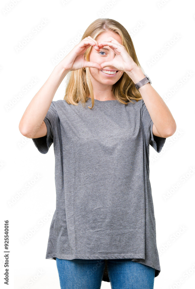 Beautiful young woman wearing oversize casual t-shirt over isolated background Doing heart shape with hand and fingers smiling looking through sign Beautiful young woman wearing oversize casual t-shirt over isolated background Doing heart shape with hand and fingers smiling looking through sign