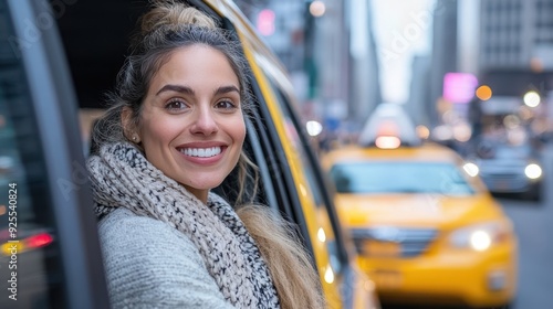 A woman, exuberantly smiling in a warm coat, enjoys a New York City cab ride, embracing the vibrant and busy atmosphere of the city's streets around her. photo