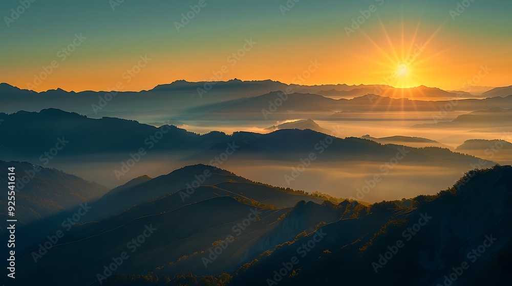 Fototapeta premium A scenic sunrise over rolling mountain peaks with mist and fog in the valleys.