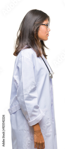 Young asian doctor woman over isolated background looking to side, relax profile pose with natural face with confident smile.