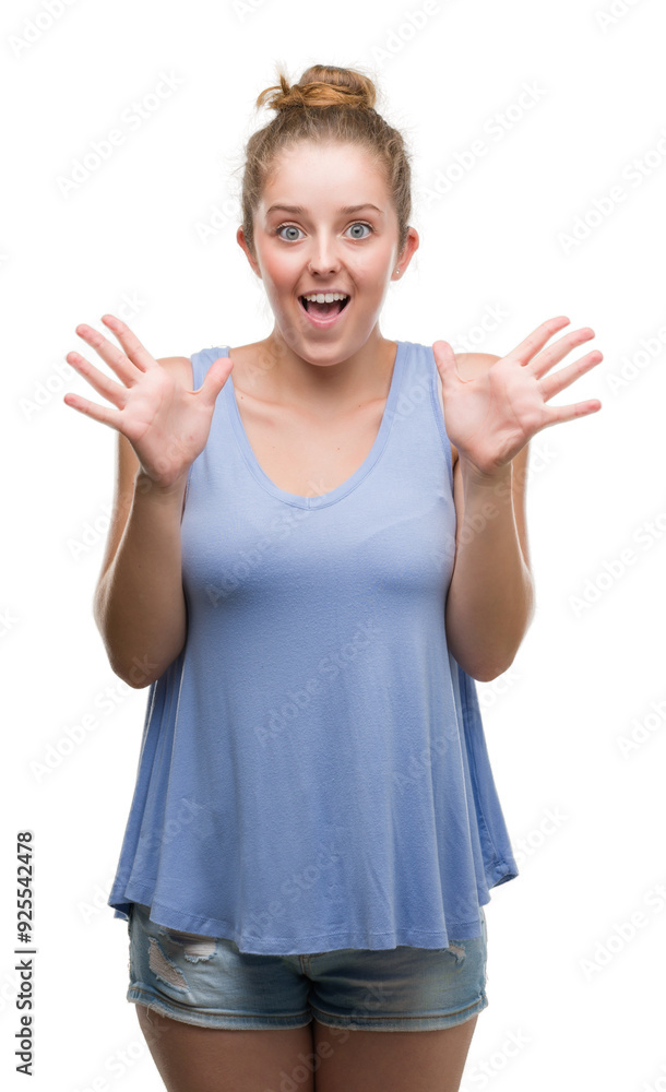 Young blonde woman celebrating crazy and amazed for success with arms raised and open eyes screaming excited. Winner concept Young blonde woman celebrating crazy and amazed for success with arms raised and open eyes screaming excited. Winner concept