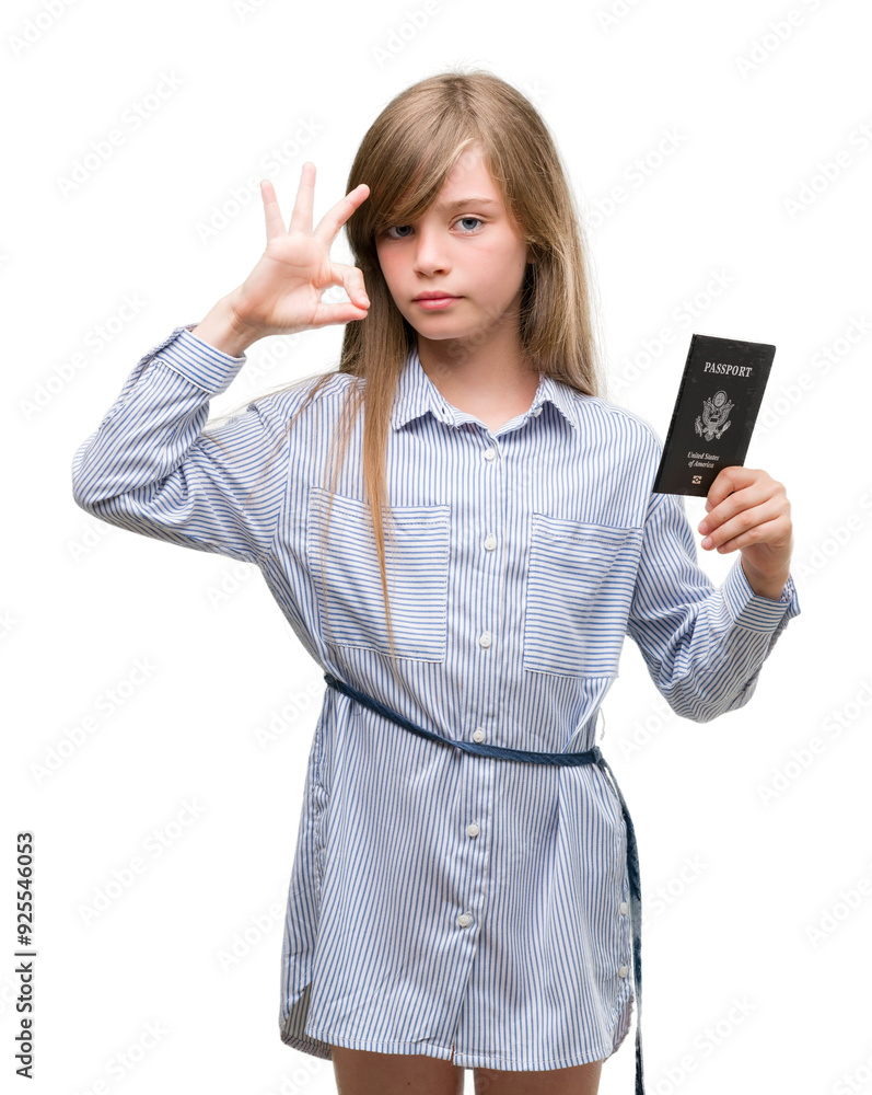Young blonde toddler holding american passport doing ok sign with fingers, excellent symbol Young blonde toddler holding american passport doing ok sign with fingers, excellent symbol