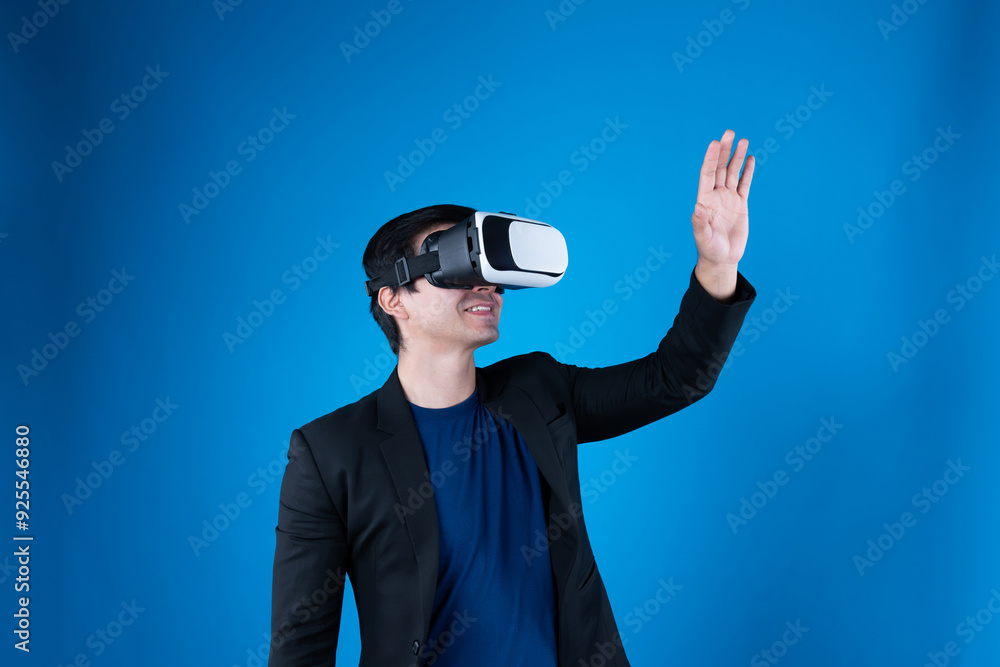 Profile businessman wearing VR headset looking to connect metaverse searching by touching slide with interesting data isolated blue background futuristic technology in virtual reality. Contrivance. Profile businessman wearing VR headset looking to connect metaverse searching by touching slide with interesting data isolated blue background futuristic technology in virtual reality. Contrivance.