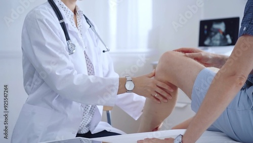Tableau sur toile Doctor is carefully examining a patient's knee, providing personalized care and support
