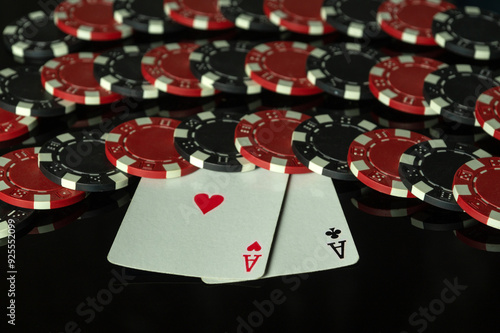 Fotografie Playing cards two aces and chips on a black table in a poker club