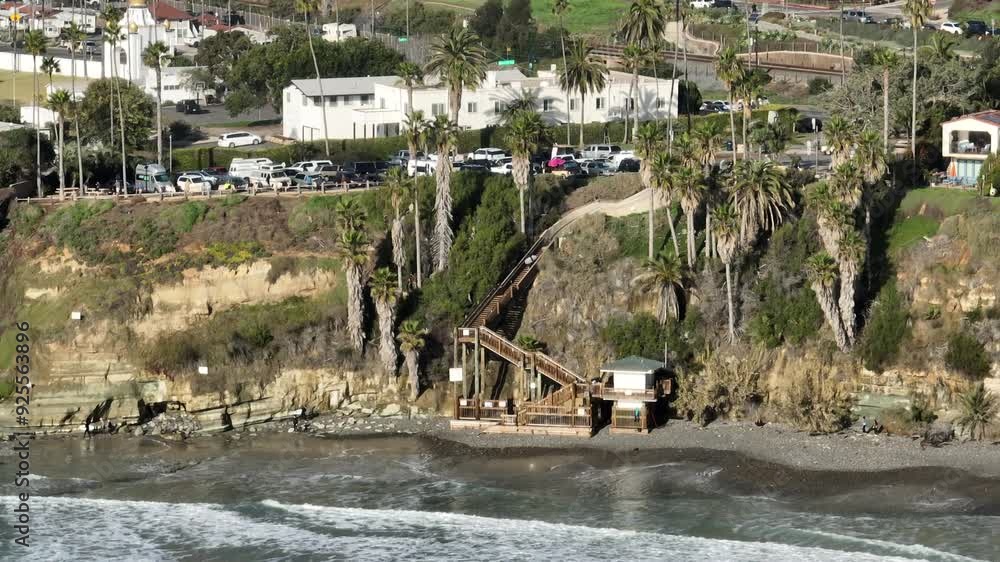 Aerial view over Swamis Beach in San Diego California on a partly cloudy day with the Pacific Ocean waves crashing along the shore