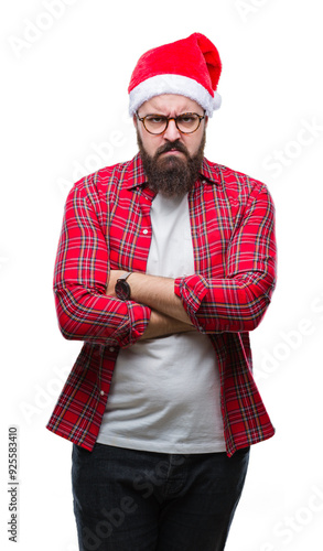 Young caucasian man wearing christmas hat over isolated background skeptic and nervous, disapproving expression on face with crossed arms. Negative person.