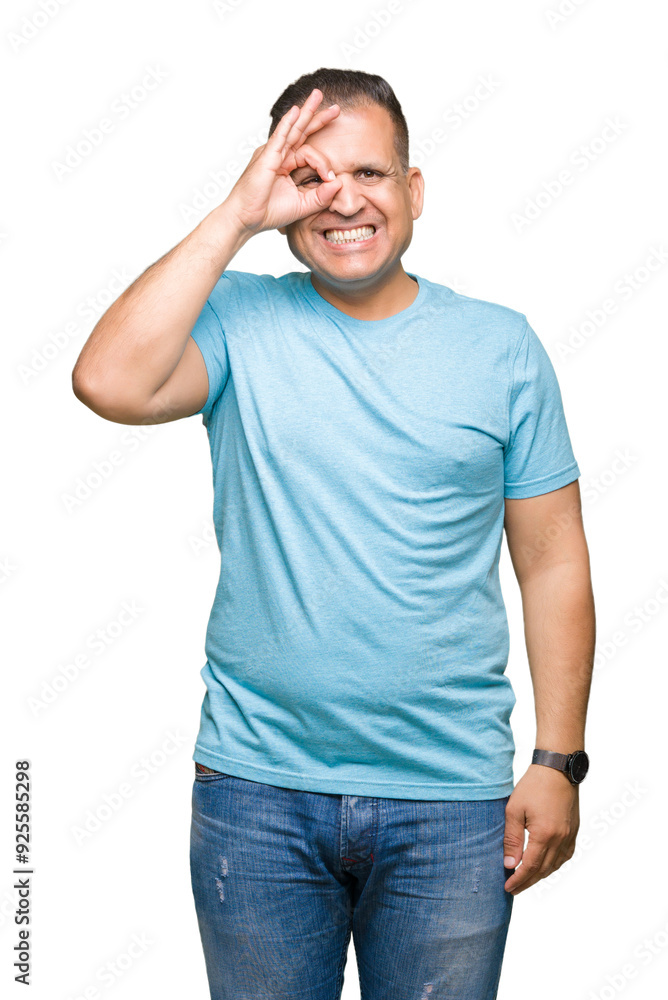 Middle age arab man wearing blue t-shirt over isolated background doing ok gesture with hand smiling, eye looking through fingers with happy face. Middle age arab man wearing blue t-shirt over isolated background doing ok gesture with hand smiling, eye looking through fingers with happy face.