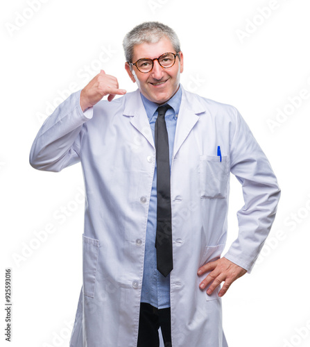 Handsome senior doctor, scientist professional man wearing white coat over isolated background smiling doing phone gesture with hand and fingers like talking on the telephone. Communicating concepts.