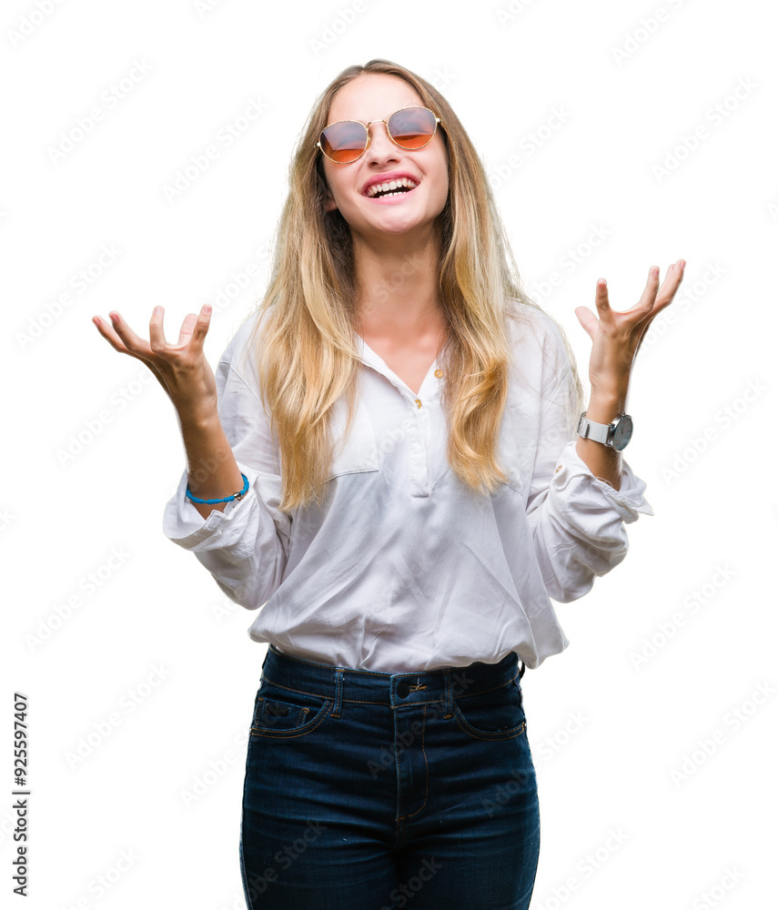 Young beautiful blonde woman wearing sunglasses over isolated background crazy and mad shouting and yelling with aggressive expression and arms raised. Frustration concept. Young beautiful blonde woman wearing sunglasses over isolated background crazy and mad shouting and yelling with aggressive expression and arms raised. Frustration concept.