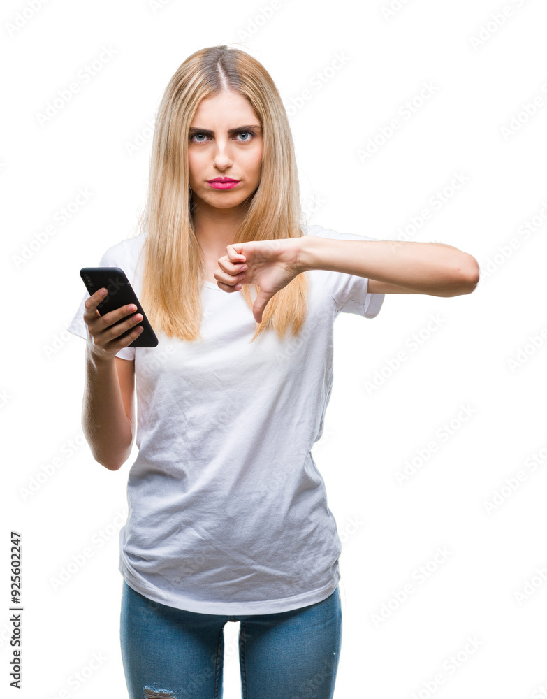 Young beautiful blonde woman using smartphone over isolated background with angry face, negative sign showing dislike with thumbs down, rejection concept