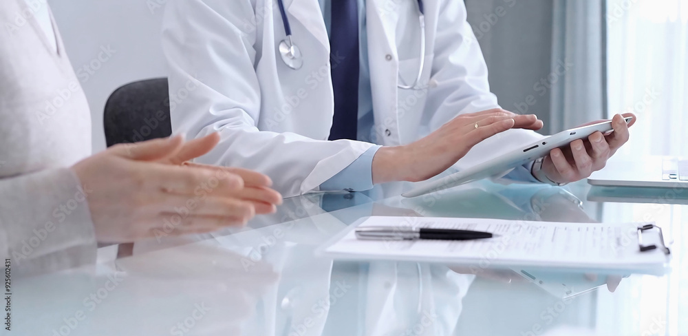Doctor is consulting patient in modern clinic. Healthcare professional discusses medical information with a woman, using a tablet computer. Medicine concept Doctor is consulting patient in modern clinic. Healthcare professional discusses medical information with a woman, using a tablet computer. Medicine concept