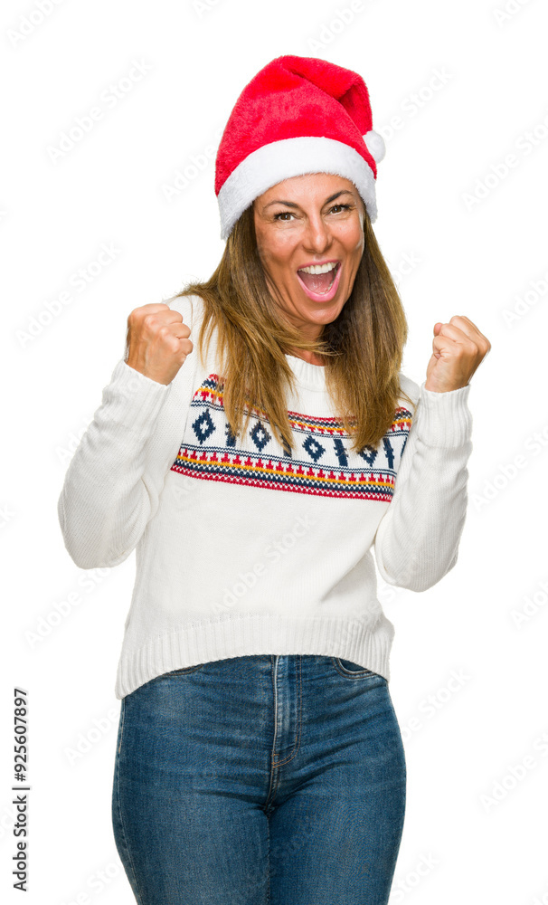 Middle age adult woman wearing winter sweater and chrismat hat over isolated background very happy and excited doing winner gesture with arms raised, smiling and screaming for success Middle age adult woman wearing winter sweater and chrismat hat over isolated background very happy and excited doing winner gesture with arms raised, smiling and screaming for success