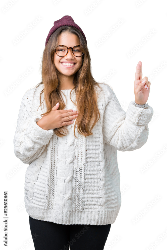 Young beautiful brunette hipster woman wearing glasses and winter hat over isolated background Swearing with hand on chest and fingers, making a loyalty promise oath Young beautiful brunette hipster woman wearing glasses and winter hat over isolated background Swearing with hand on chest and fingers, making a loyalty promise oath