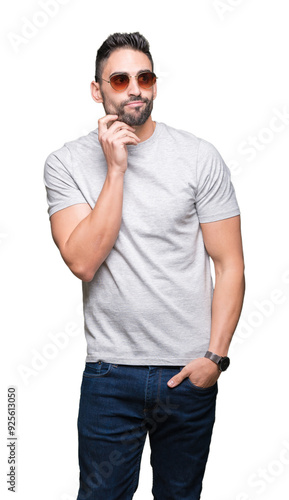 Young handsome man wearing sunglasses over isolated background with hand on chin thinking about question, pensive expression. Smiling with thoughtful face. Doubt concept.