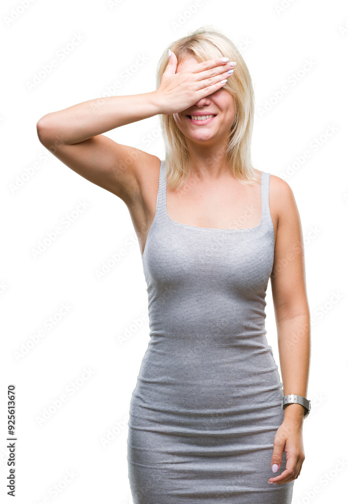 Young beautiful blonde woman over isolated background smiling and laughing with hand on face covering eyes for surprise. Blind concept. Young beautiful blonde woman over isolated background smiling and laughing with hand on face covering eyes for surprise. Blind concept.
