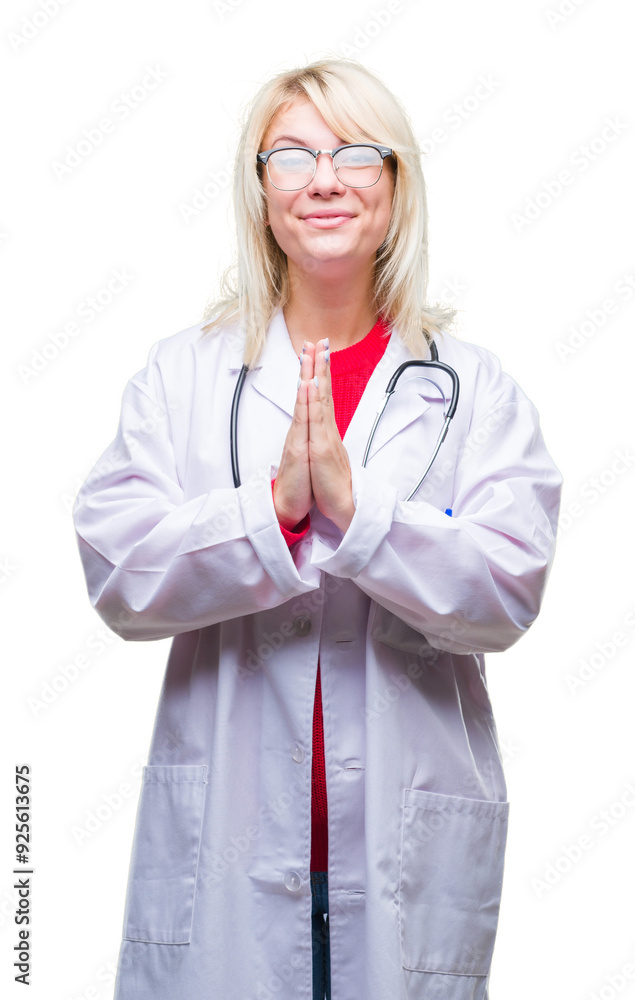 Young beautiful blonde doctor woman wearing medical uniform over isolated background praying with hands together asking for forgiveness smiling confident. Young beautiful blonde doctor woman wearing medical uniform over isolated background praying with hands together asking for forgiveness smiling confident.