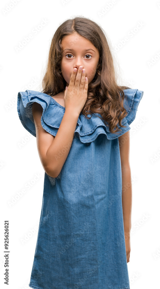 Brunette hispanic girl wearing denim dress cover mouth with hand shocked with shame for mistake, expression of fear, scared in silence, secret concept Brunette hispanic girl wearing denim dress cover mouth with hand shocked with shame for mistake, expression of fear, scared in silence, secret concept