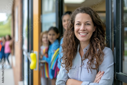 Woman with curly hair smiling in school doorway