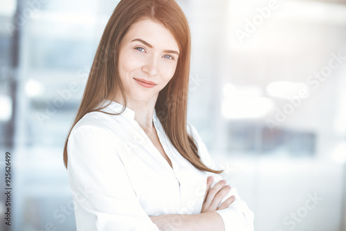 Beautiful female specialist with arms crossed standing in sunny office and smiling charmingly. Business people concept Free Download Beautiful female specialist with arms crossed standing in sunny office and smiling charmingly. Business people concept - GFXLoad