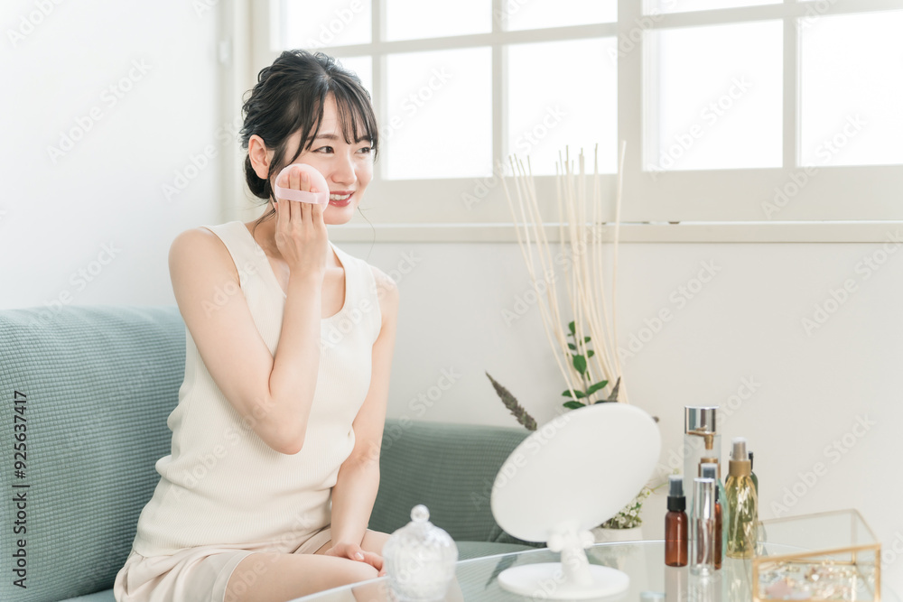 ファンデーション・パウダー・メイクする笑顔のアジア人女性
