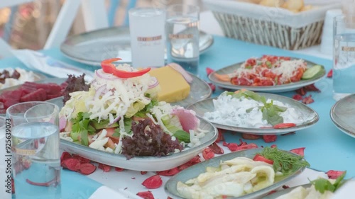 A colorful spread of traditional Turkish meze dishes on a table, including salads, appetizers, and glasses of raki, offering a delightful and cultural dining experience. photo